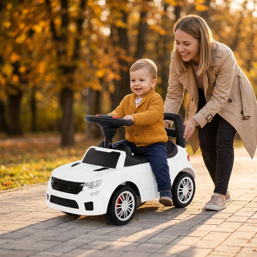 Guralica auto beli na popločanoj stazi u jesenjem parku sa detetom koje se odguruje