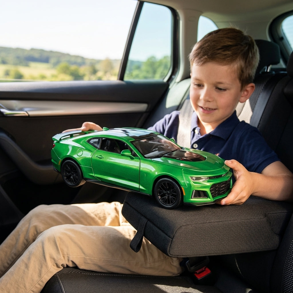 Metalni autić Chevrolet Camaro u rukama dečaka tokom putovanja automobilom