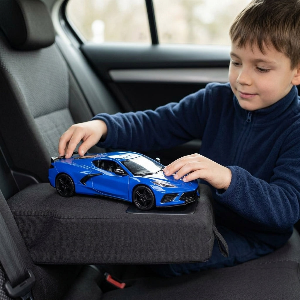 Metalni autić Chevrolet Corvette C8 1:24 u rukama dečaka tokom putovanja kolima