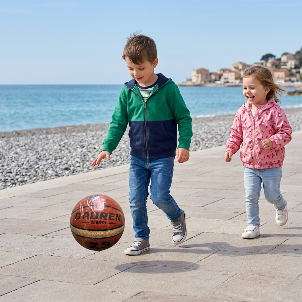 Košarkaška lopta braon tokom dečije igre na kamenom šetalištu pored plaže