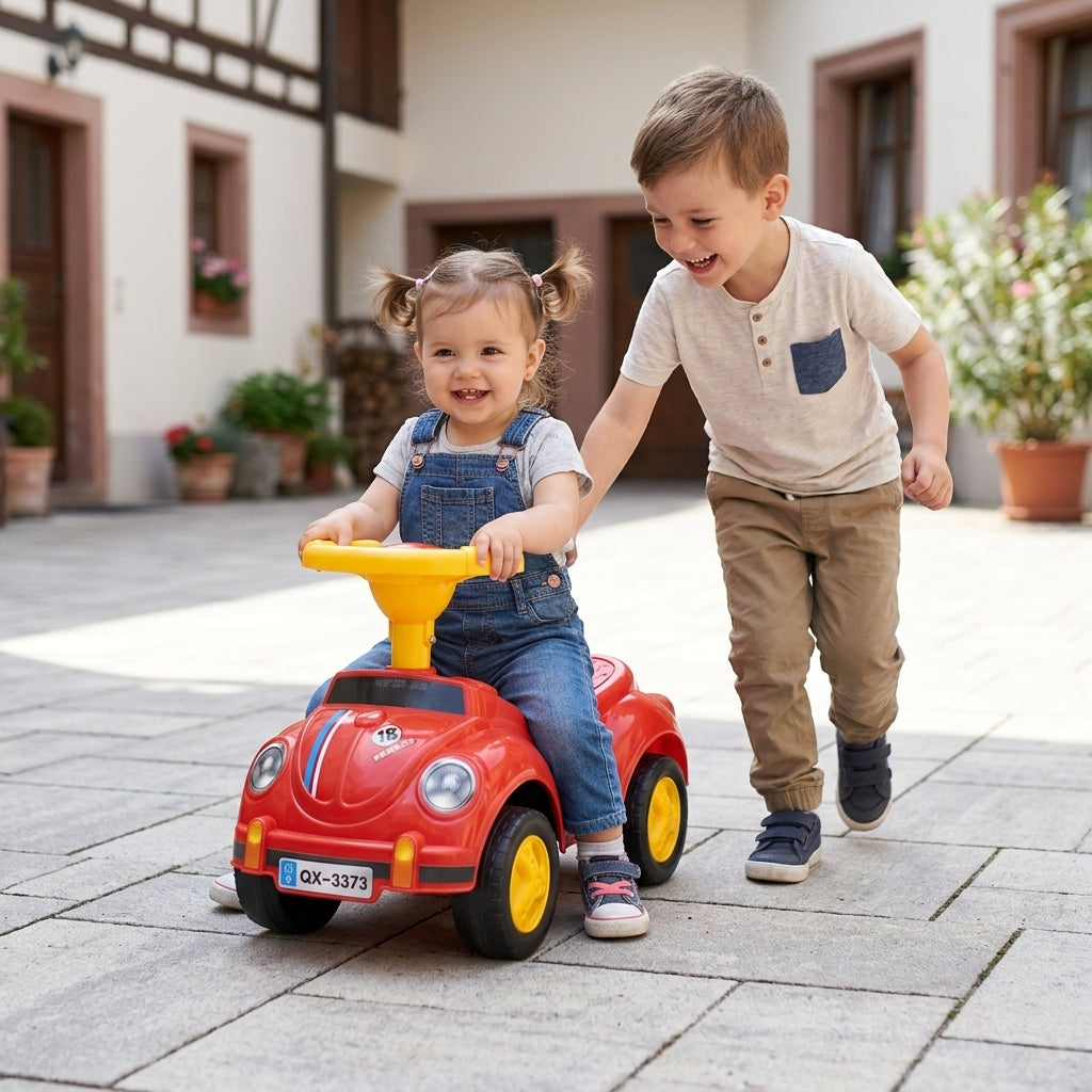 Auto guralica jednosed u dvorištu dok se sestra i stariji brat igraju zajedno