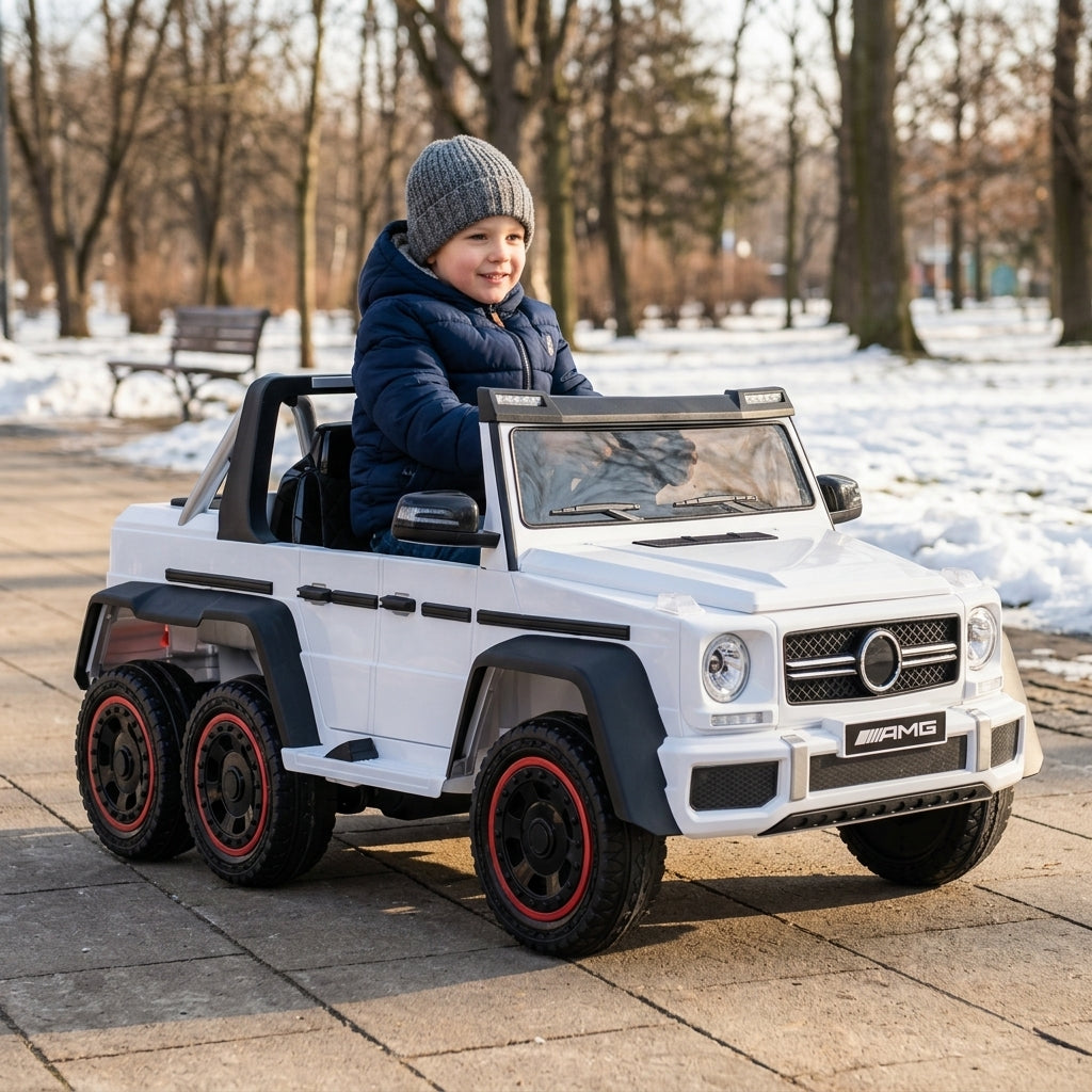 Džip na akumulator beli Mercedes 6x6 koji dečak vozi u parku tokom zime